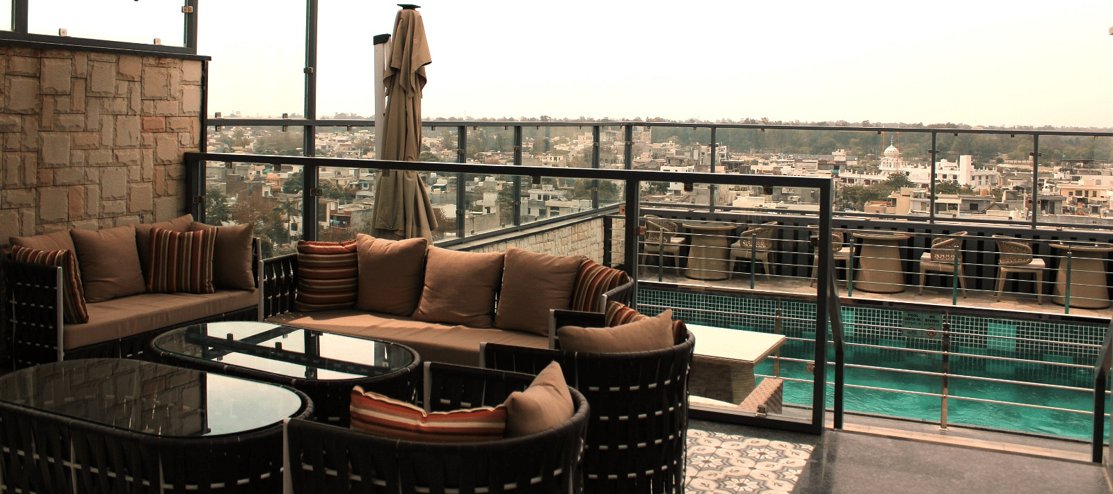A rooftop lounge with a spacious patio and an adjacent swimming pool at BluSalzz Residence, Amritsar